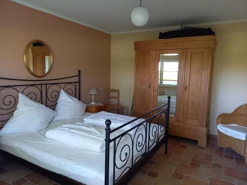 une chambre avec un lit avec des draps blancs et un miroir dans l'établissement Gutshaus von Bülow - 19-01, à Kägsdorf