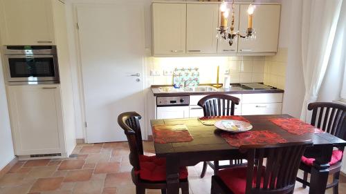 une cuisine avec une table et des chaises et une cuisine avec un évier dans l'établissement Gutshaus von Bülow - 19-01, à Kägsdorf