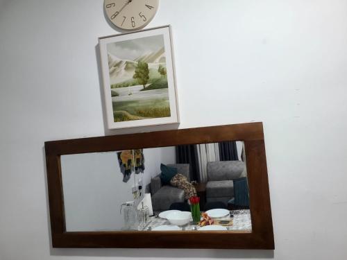 a mirror in a living room with a clock on the wall at Seven S villa in Kamburugamuwa