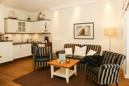 een woonkamer met een bank, stoelen en een tafel bij Dünenschloss - 02-24 in Kühlungsborn