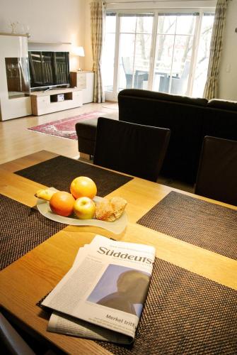 a table with a plate of fruit and a newspaper on it at Alexandra - 13-20 in Kühlungsborn