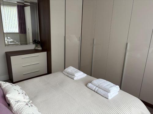 a bedroom with a bed with two towels on it at The Knutsford Bungalow in Knutsford