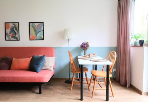 a living room with a red couch and a table at Wygodne mieszkanie dla dwojga in Bystrzyca Kłodzka