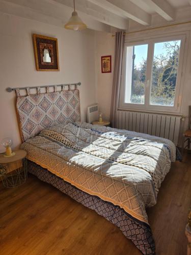 a bedroom with a bed and a window at LA Chataigne in Santranges