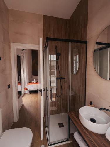 a bathroom with a shower and a toilet and a sink at La Banda Suites in Seville