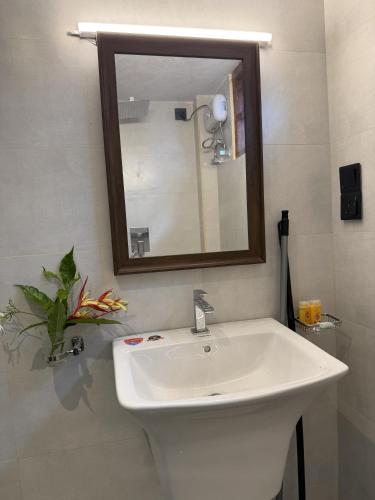 a bathroom with a white sink and a mirror at Villa By Dissa in Dikwella North