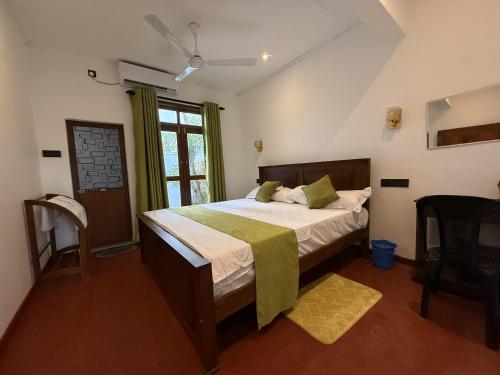 a bedroom with a bed with a green blanket on it at Villa By Dissa in Dikwella North