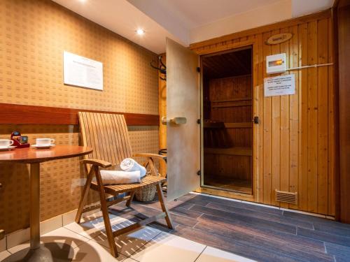 een kamer met een stoel, een tafel en een kast bij Mercure Cieszyn in Cieszyn