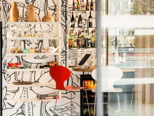 a red chair in a room with a window at Hotel ibis Rennes Centre Gare Sud in Rennes