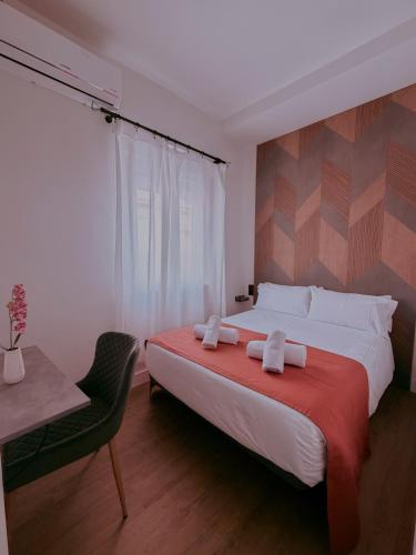a bedroom with a large bed and a chair at La Banda Suites in Seville