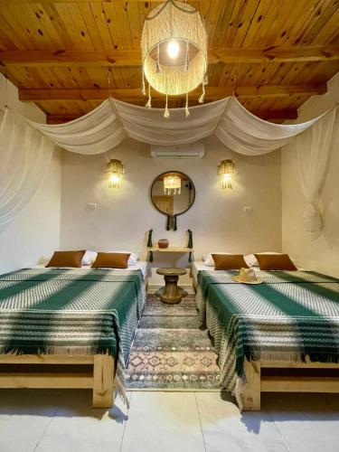 a bedroom with two beds and a chandelier at Timber House Dahab in Dahab