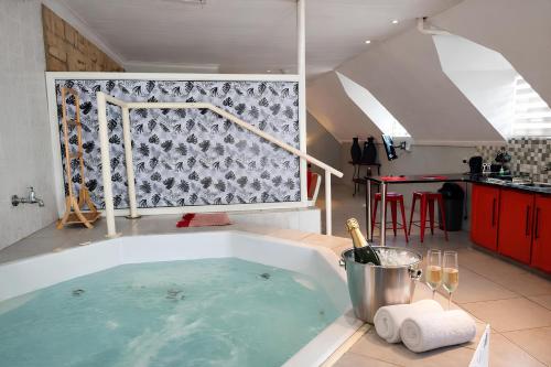 een groot bad met een fles wijn erin bij The Villa Manor & Spa Exclusive Escape in Bela-Bela