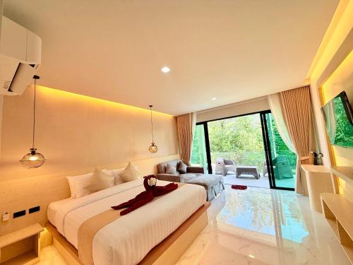 a bedroom with a large bed and a large window at Pure Sand Lanta Resort in Ko Lanta