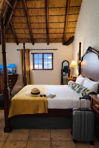 a bedroom with a large bed with a hat on it at The Villa Manor & Spa Exclusive Escape in Bela-Bela