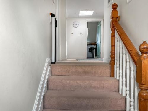 een hal met een trap met een spiegel en een trap bij Sandbourne in Bournemouth