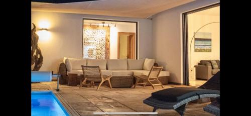 a living room with a couch and chairs and a pool at Casa Mila with heated pool in El Roque in Cotillo