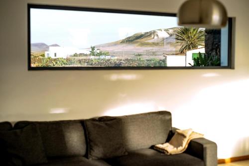 a television hanging on a wall above a couch at Casa Mila with heated pool in El Roque in Cotillo