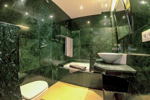 een groene badkamer met een wastafel en een toilet bij Casa Maeva with heated pool in El Roque in Cotillo