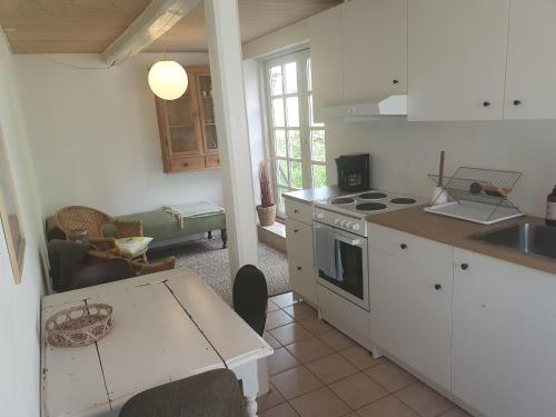 a kitchen with a table and a stove top oven at Slotsgaardens ferielejlighed in Rødding