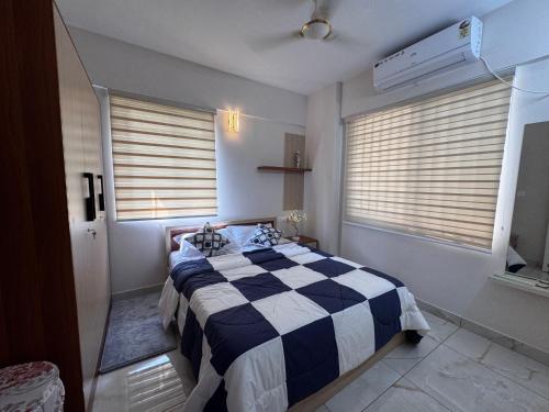 a bedroom with a black and white checkered bed at Zenith apartement in Trivandrum