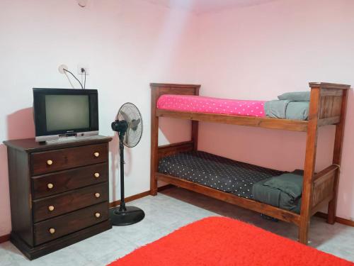 een slaapkamer met 2 stapelbedden en een televisie bij La casita de Sanber in San Bernardo