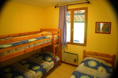 a bedroom with two bunk beds and a window at Mirabel #3, Maisonette, terrace and pool access in Grospierres