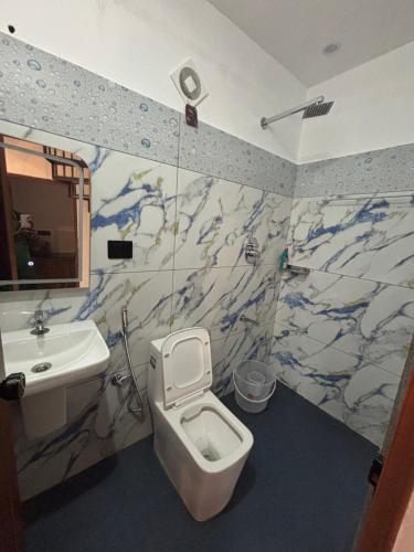 a bathroom with a white toilet and a sink at Bethel Cottage in Kanthalloor