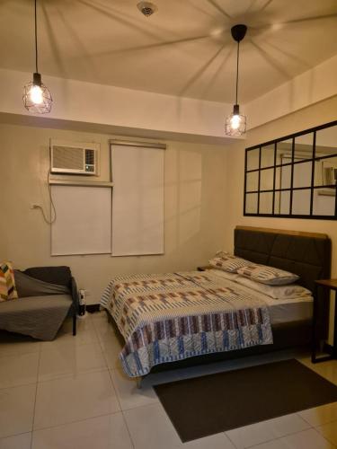 a bedroom with a bed and a couch and lights at Jacob's Place Near Manila Airport in Manila
