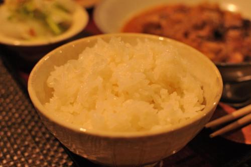 a bowl of rice on a table with food at Hostel&Bar CAMOSIBA in Yokote