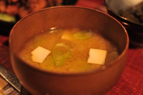 a bowl of soup with cheese in it on a table at Hostel&Bar CAMOSIBA in Yokote