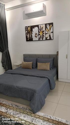 a bedroom with a bed with two pictures on the wall at Mesahill Premier Suite-Wi-Fi-NETFLIX in Nilai