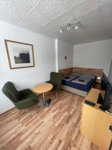 a room with a bed and a table and a desk at Malý apartmán na Šumavě in Horní Vltavice