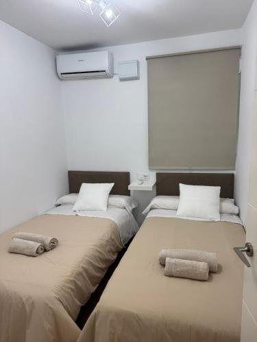 two beds in a room with towels on them at Velazquez in Lora del Río