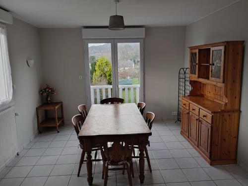 a dining room with a table and chairs and a window at La Petite Maison Celtique in Saint-Nicolas-du-Pélem
