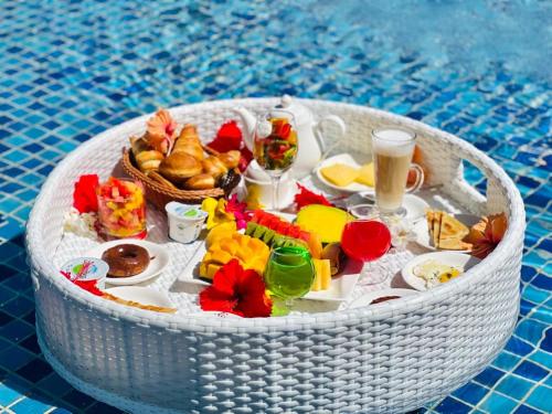een witte tafel met eten en drinken in een zwembad bij Matemwe Sands Hotel in Mkuyuni Pwani