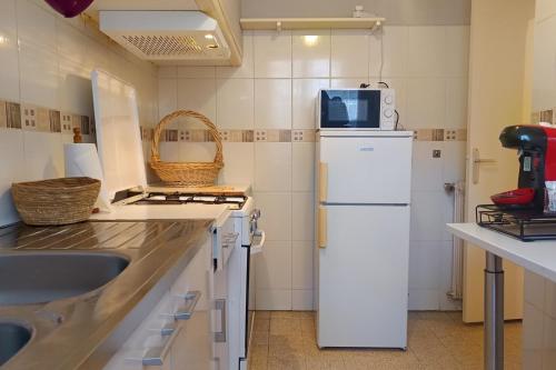 a kitchen with a white refrigerator and a sink at Spacious house in Perpignan quiet and friendly in Perpignan