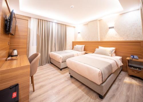 a hotel room with two beds and a television at Zirvesta Otel in Istanbul