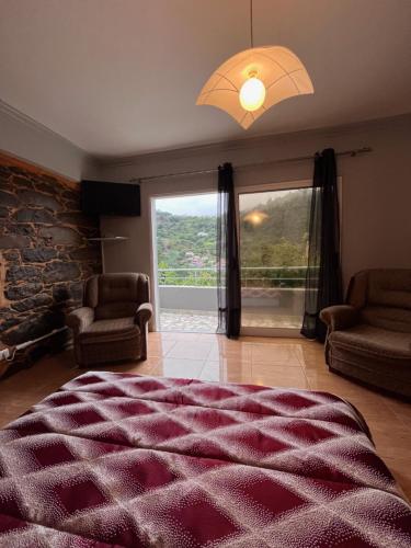 a bedroom with a large bed and a large window at Casa Duque in Santana with AC and heating in Santana