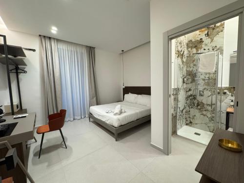 a bedroom with a bed and a desk and a chair at Hart Boutique Rooms in Naples