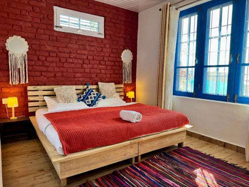 a bedroom with a bed with a red brick wall at Private Farm Villa With Plunge Pool, Bir Billing - Rishi Casa Blu in Bīr