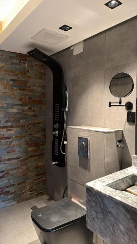 a bathroom with a stone wall and a sink at Merya Chalets - Al Shafa in Ash Shafa