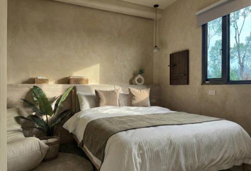 una camera da letto con un grande letto bianco e una pianta di Forgotten Boundless Offland a Wujie