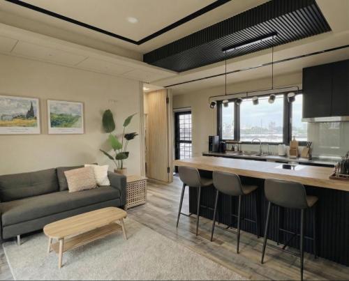 a kitchen and living room with a couch and a table at Forgotten Boundless Offland in Wujie