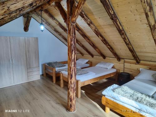a room with three beds in a log cabin at River Haus in Călineşti