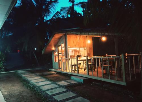 a small house with a table and chairs at night at Seasons Four Mini Jungle Cabana in Matara