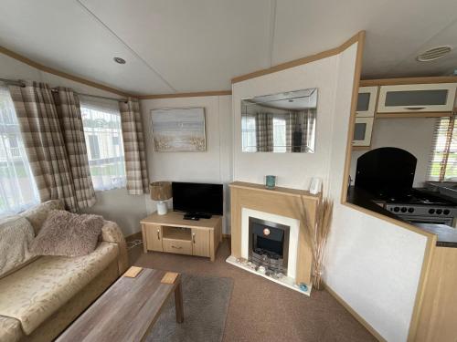 a living room with a couch and a fireplace at Seaside Sanctuary in Hemsby
