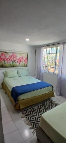 a bedroom with a large bed and a window at Casa La Fe in Cartagena de Indias