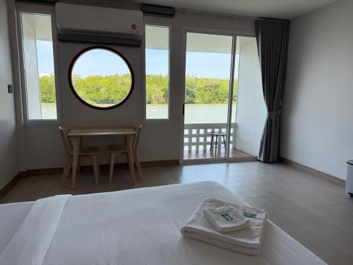 a bedroom with a bed and a large window at Madee House - มาดีเฮ้าส์ in Ban Ao Yang