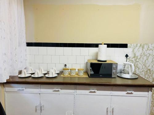 a kitchen with a counter top with a microwave at Rainbow Palace in Bloemfontein