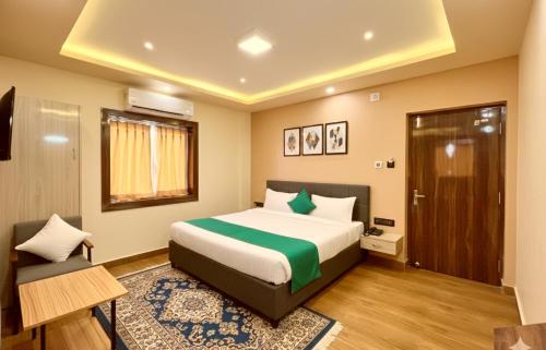 ein Schlafzimmer mit einem Bett und einem Stuhl darin in der Unterkunft Sea View From Rooftop The AOP Luxuaray Hotel - Jagannath Temple - Sea Beach - Lift-Parking And Restaurant Facilities - Fully Air Conditioning Luxuary Rooms - Best Hotel In Puri in Puri